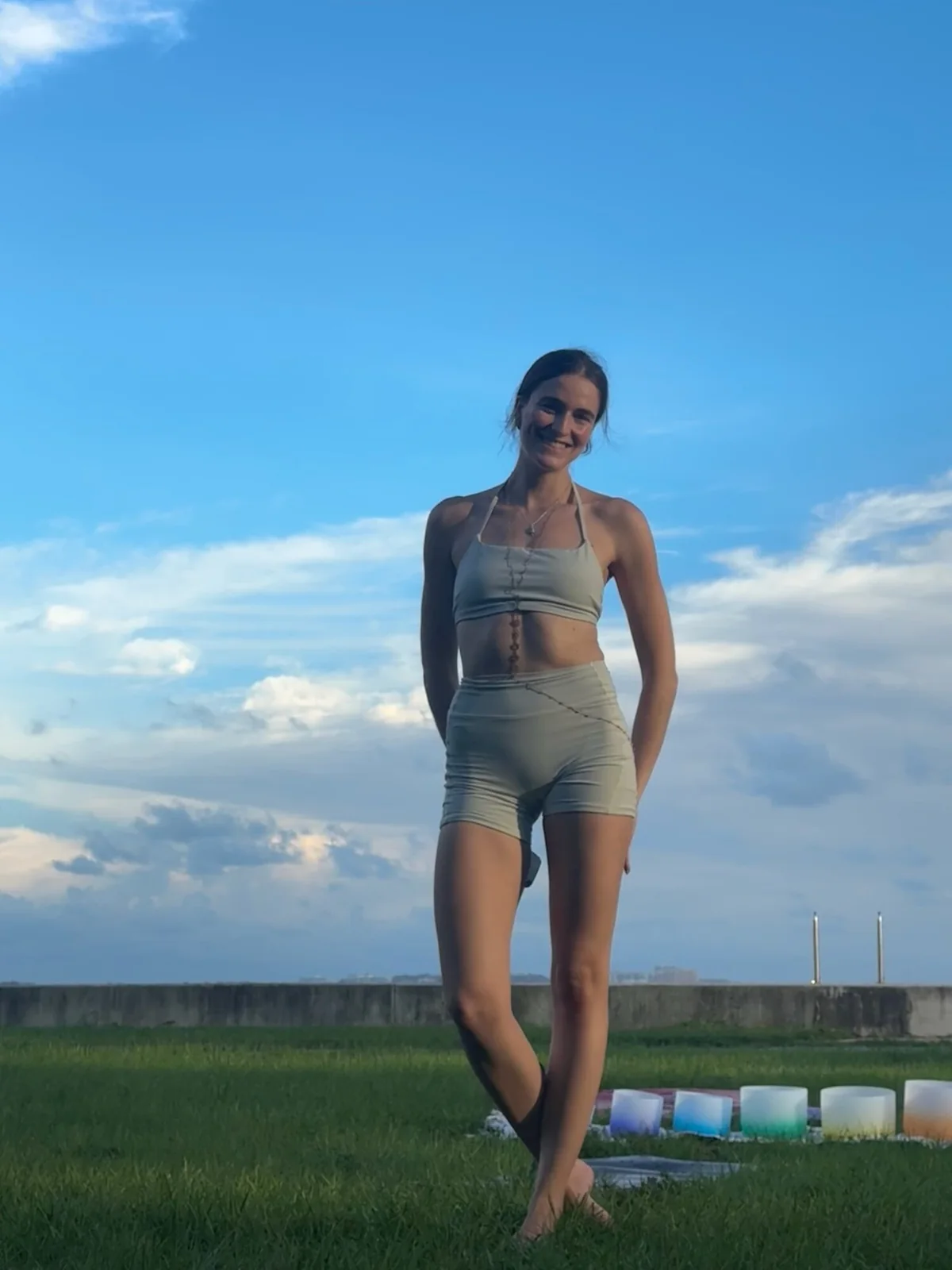 Tatiana Gentile smiling by the waterfront in a light yoga outfit