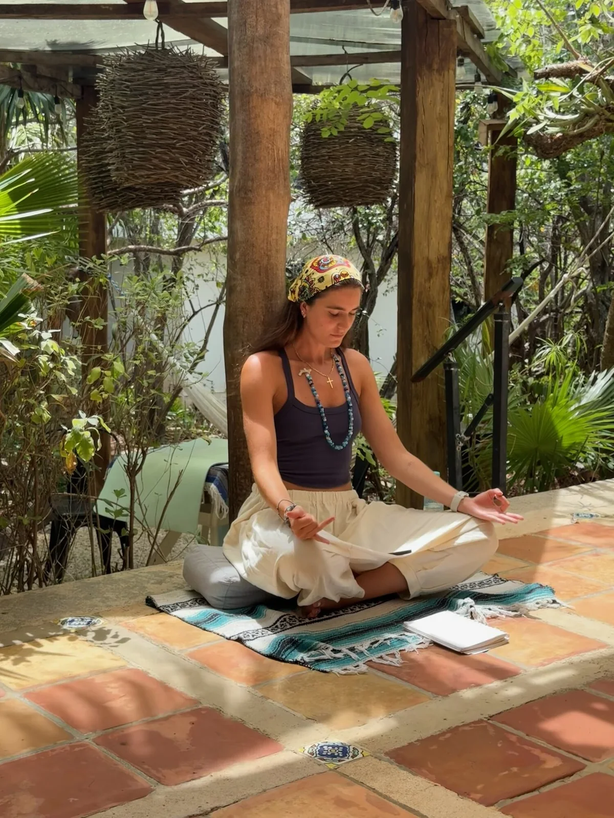 Tatiana Gentile seated in meditation on a tropical terrace